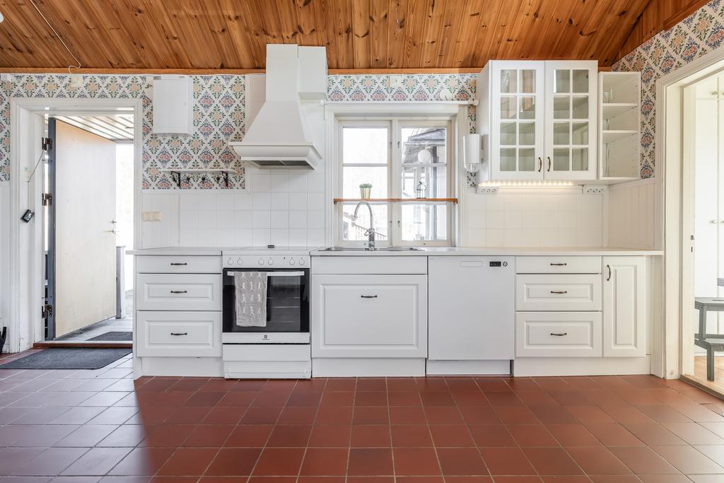 Stort kök med vattenburen golvärme samt kakelkamin med fläkt och utgång till inglasad altan.