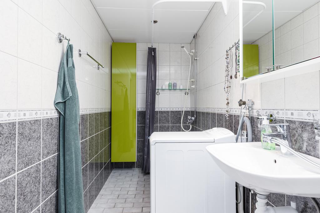 Helkaklat badrum med tvättmaskin, badkar och dusch