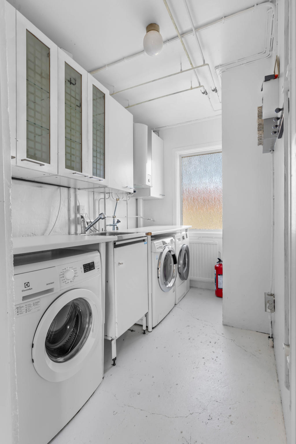 Tvättstuga med tvättmaskin, torktumlare och tvättbänk