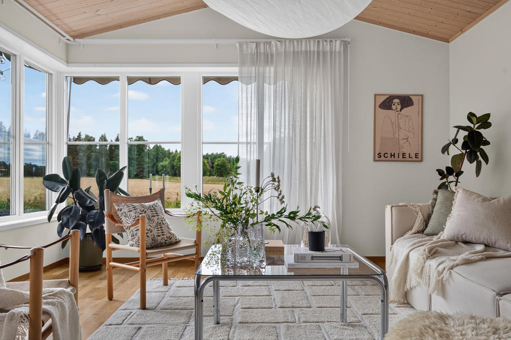 Ljust och härligt vardagsrum med stora fina fönsterpartier mot öppna ängar.