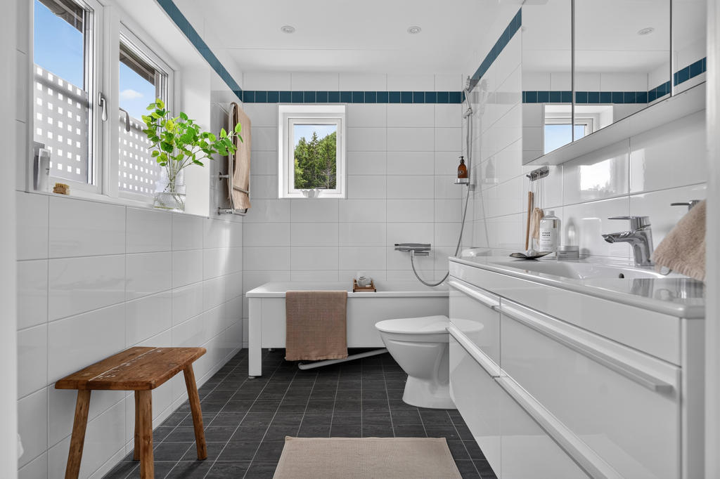 Rymligt badrum på övre plan utrustat med wc, handfat med kommod, badkar samt golvvärme.