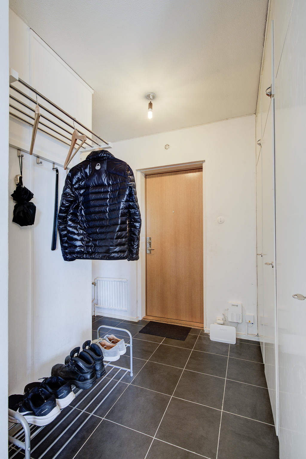 Rymlig hall med inbyggda garderober. Klinker på golv.