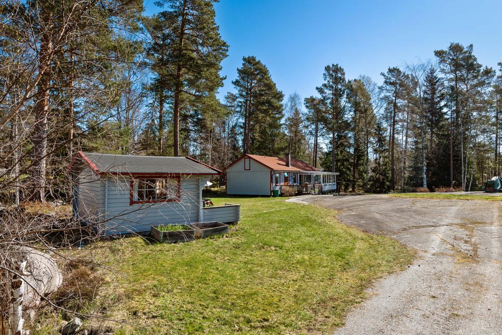 Plan och ljus tomt med gräsmatta och berghäll.