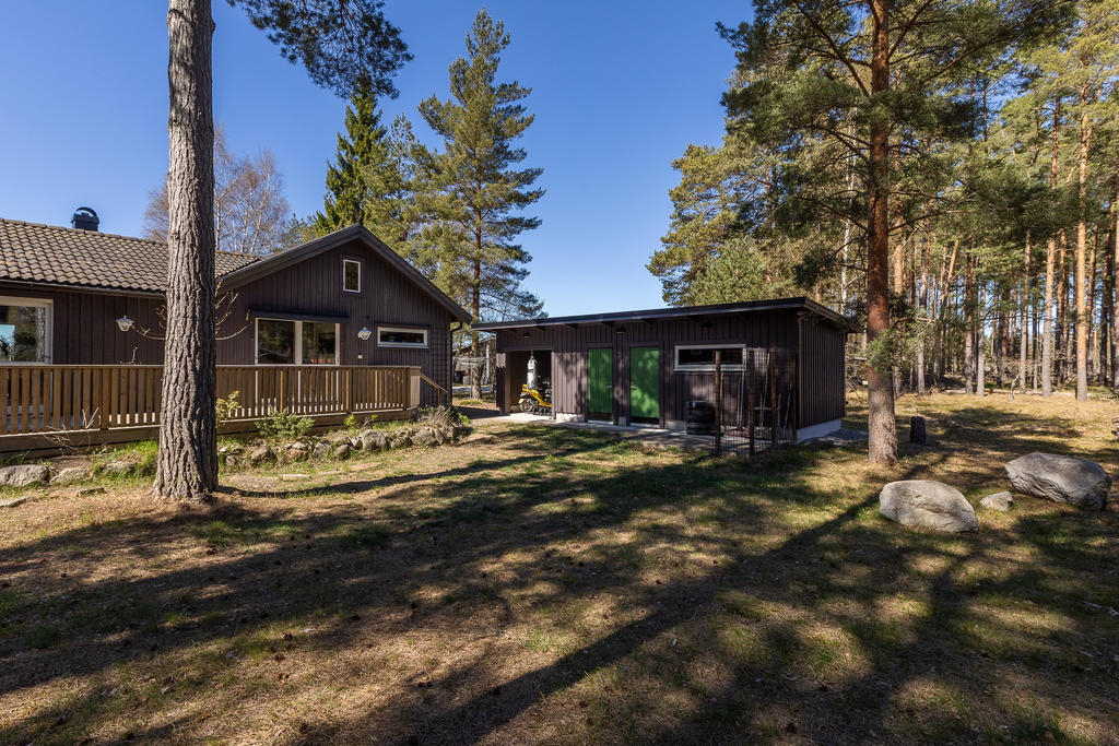 Altan åt öster för frukostkaffet. Förrådslänga som även, dörren till höger, innehåller ett isolerat gästrum.