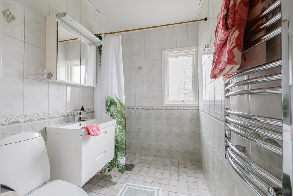 Helkaklat badrum utrustat med duschplats, kommod, spegelskåp, wc samt handukstork