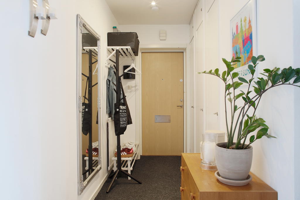 Ingång till en ljus hall med klädavhängning och ytterligare förvaring i inbyggda garderober 