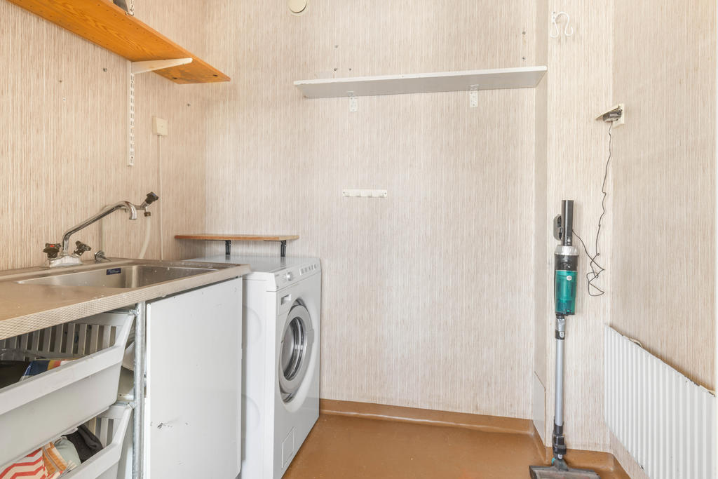 Tvättstuga med tvättbänk och tvättmaskin