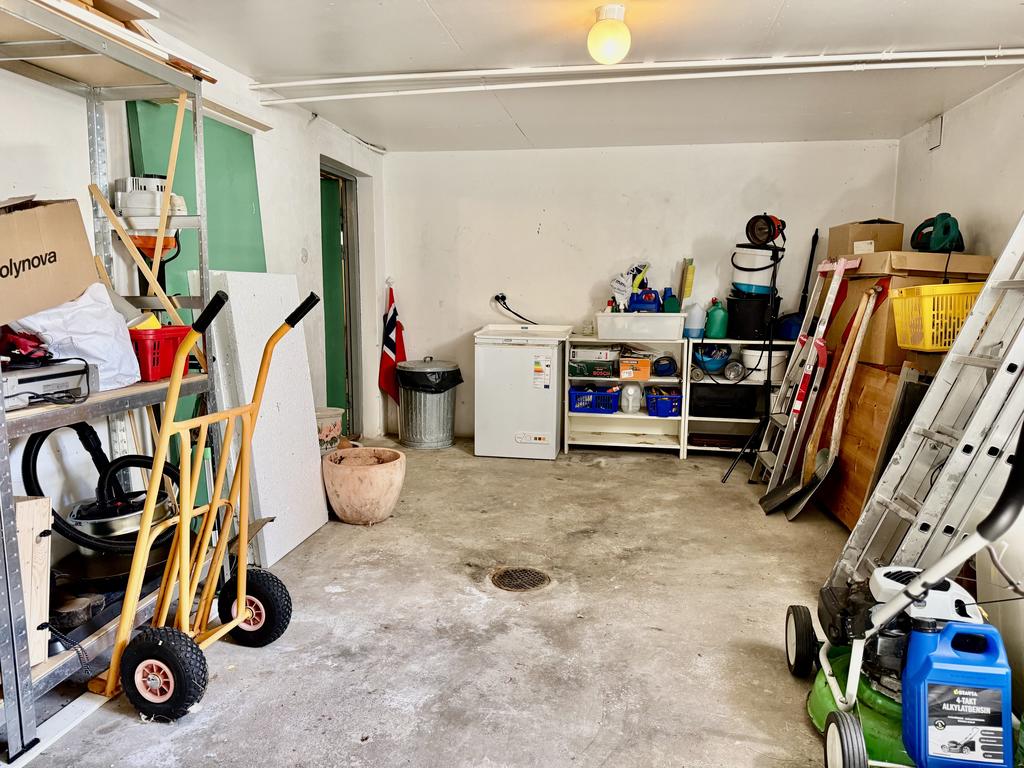 Rymligt garage med plats för bil samt ingång till källare.