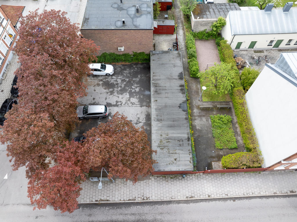 Parkering, carport och lekytor bakom skyddande plank