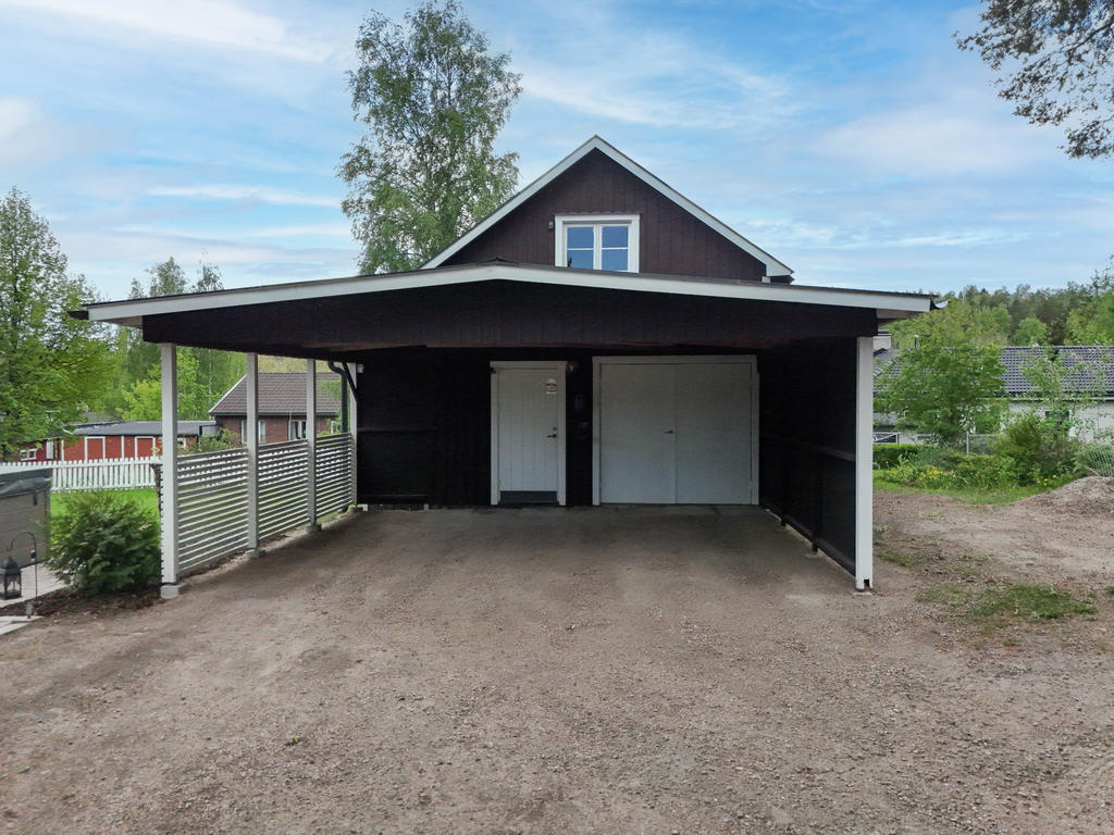 Carport framför uthus med enklare mindre garage.
