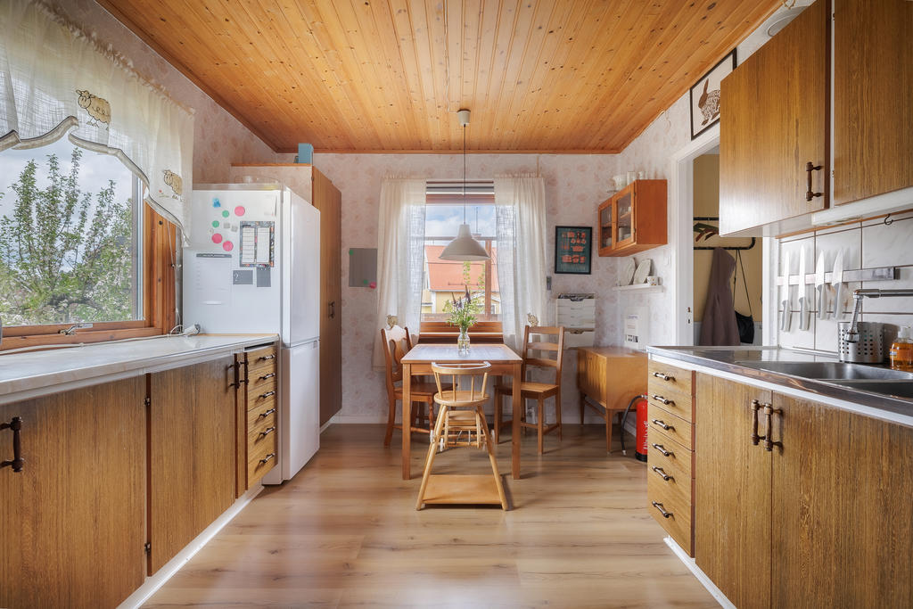 Kök med plats för matbord, utrustat med fläkt, spis, kyl och frys