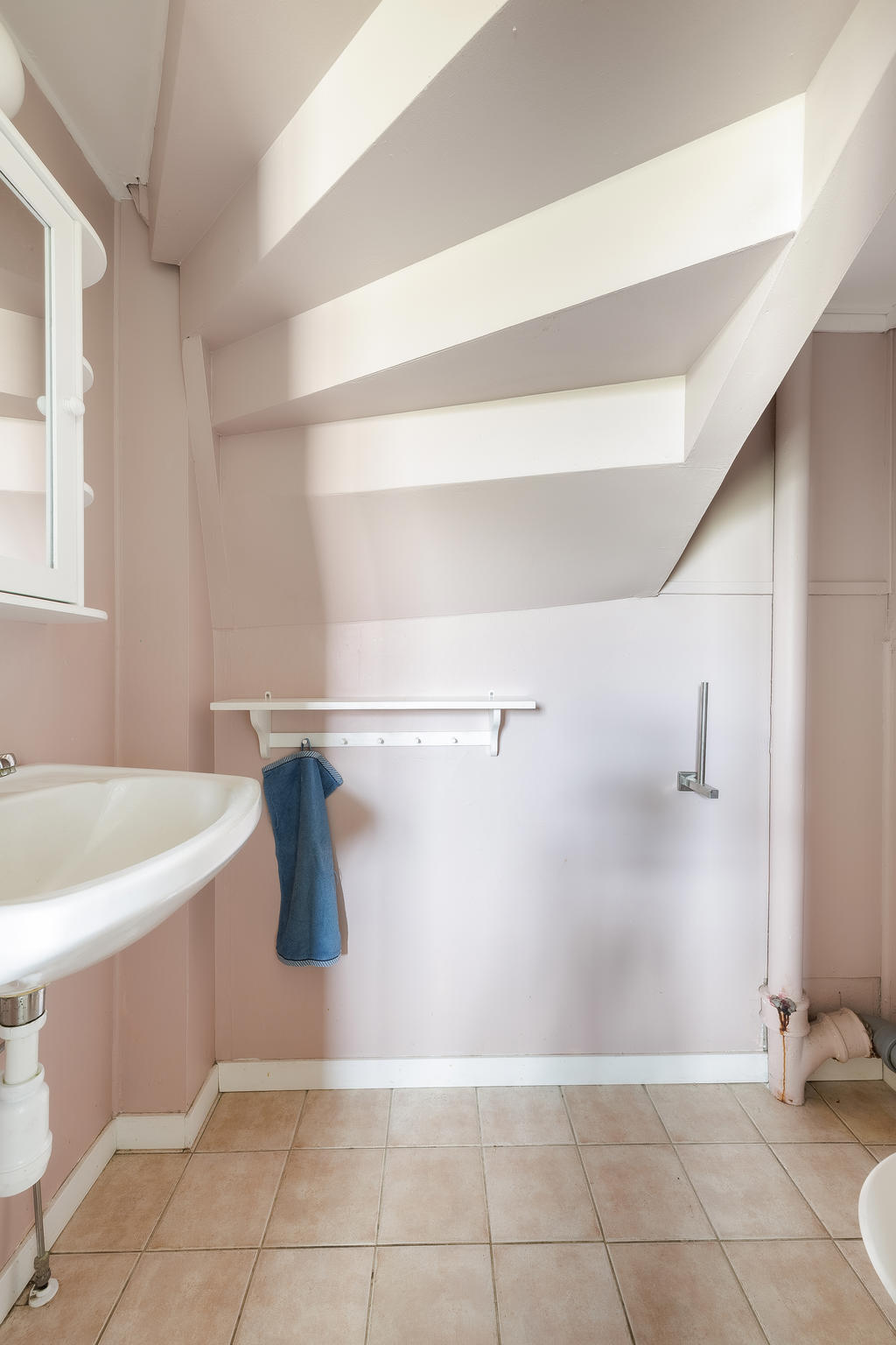 Toalett med klinkergolv, utrustat med wc, handfat och spegelskåp