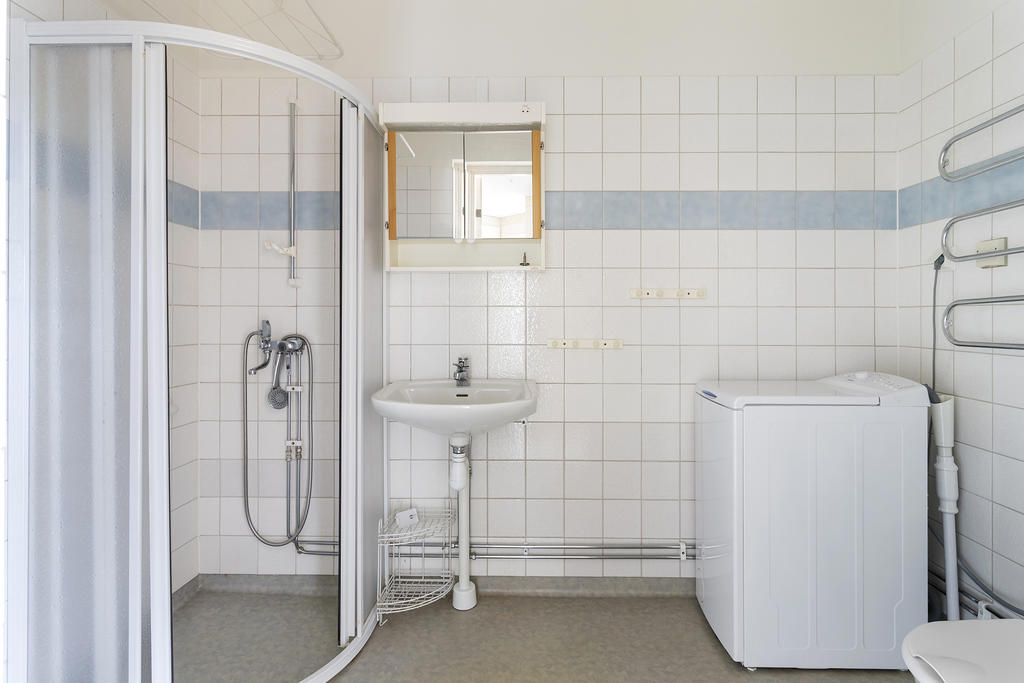 Badrum med dusch och tvättmaskin