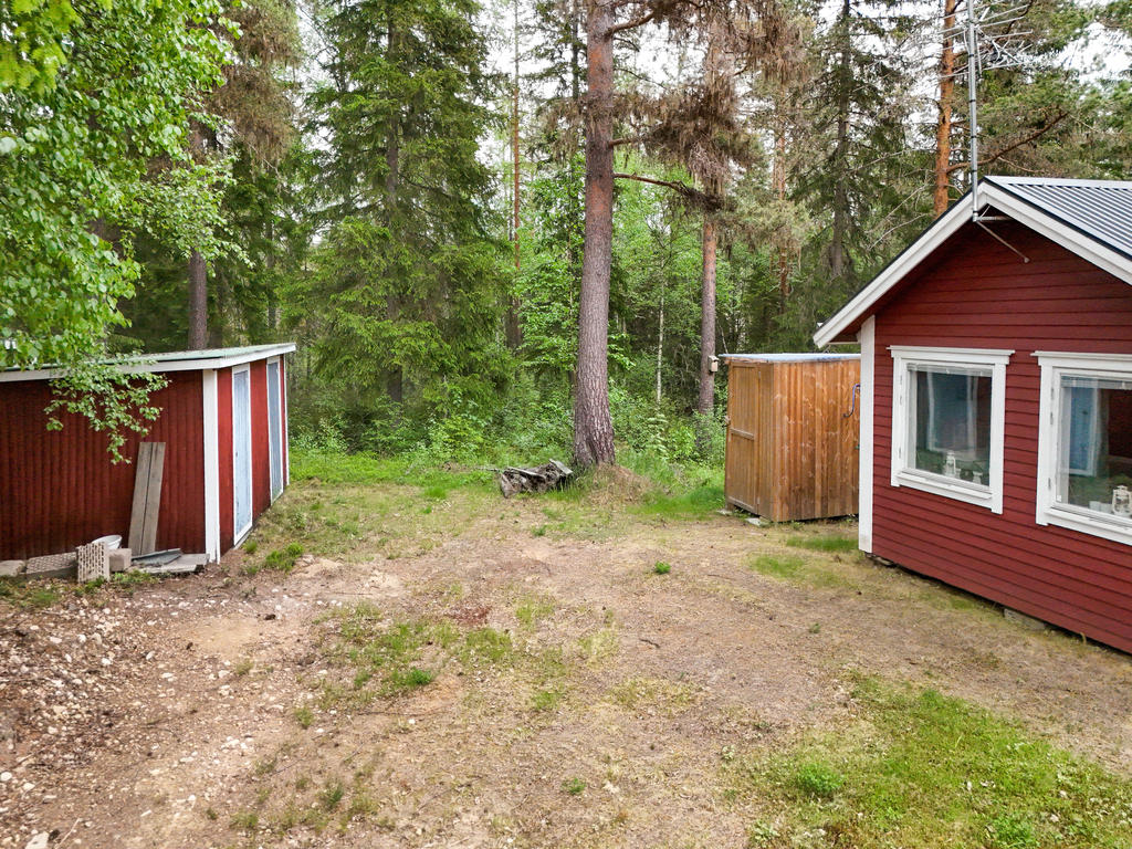 Här har du naturen och skogen in på knuten. Uthus med förråd till vänster och en utedusch-kur till höger. 