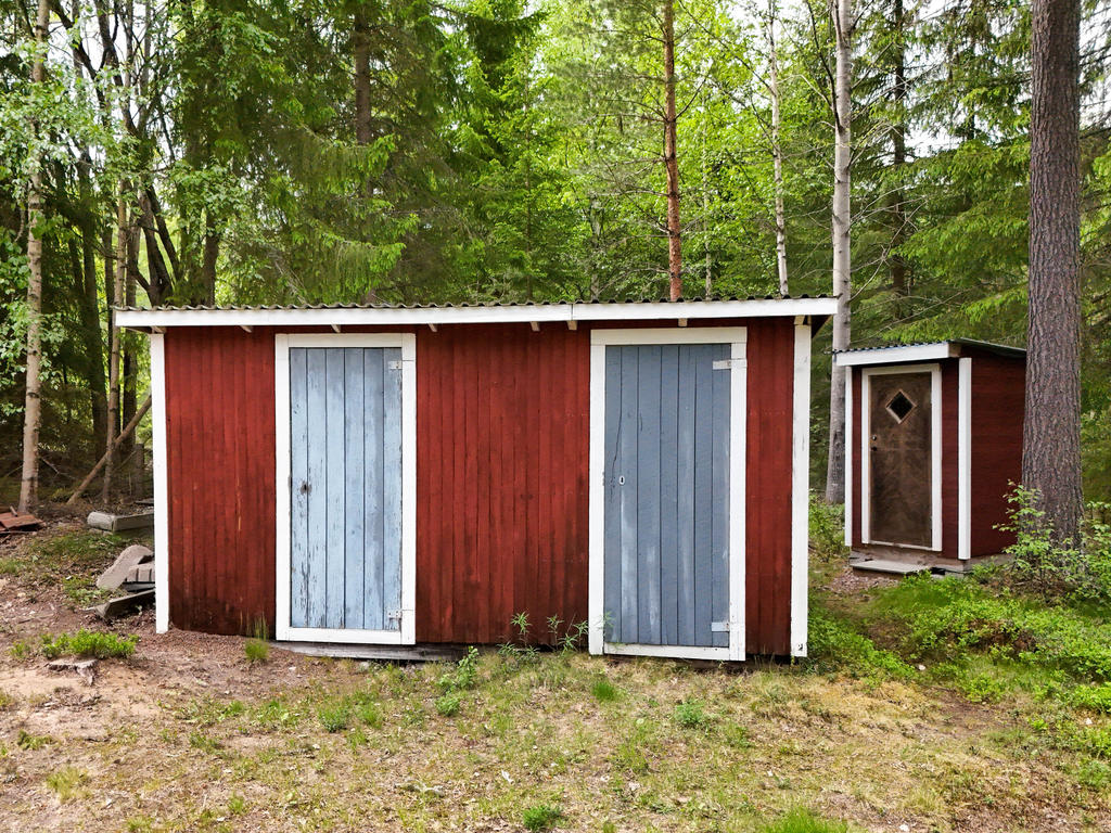 Uthus med förrådsbodar och ett  fristående utedass.