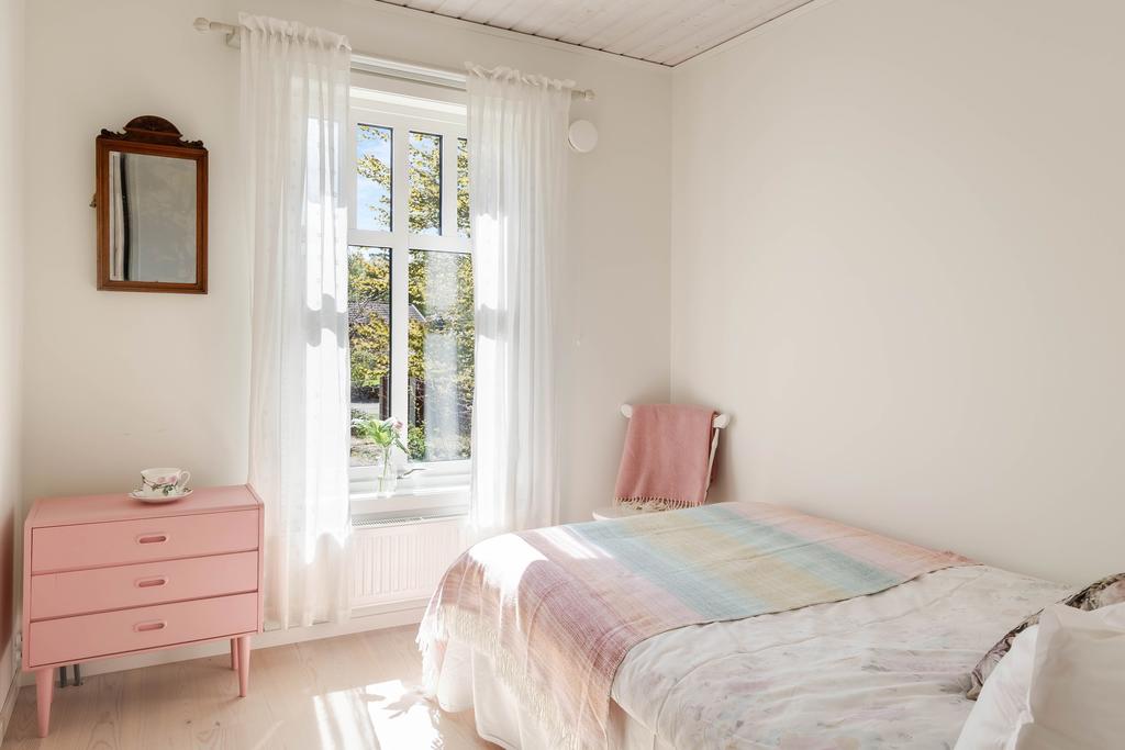 Rofyllt sovrum med plats för både säng och mindre möblemang.