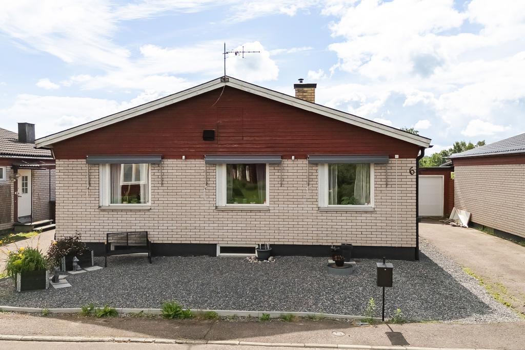 Framsidan med parkering och garage. 