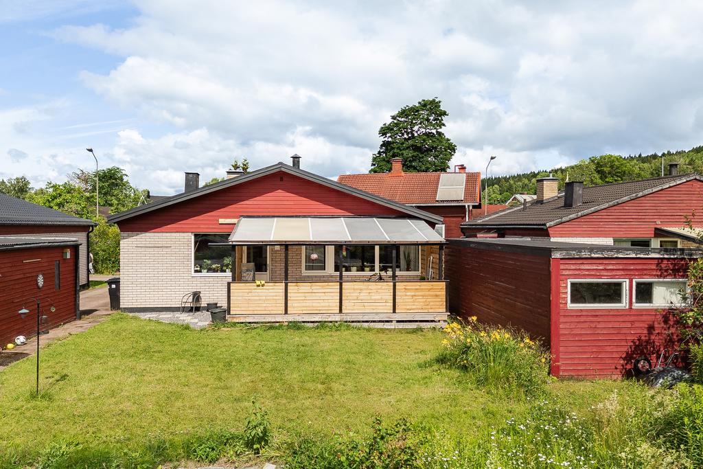 Baksidan med takad altan och gräsmatta med odlingsmöjligheter.