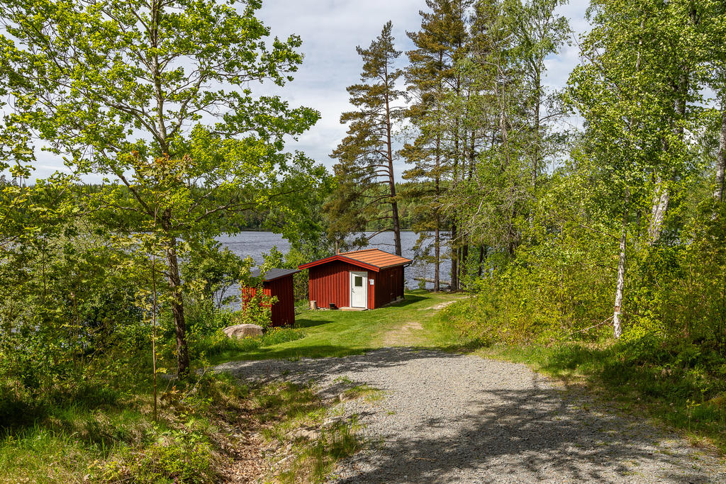 Ner mot gemensam badplats med bastu, brygga och grillplats
