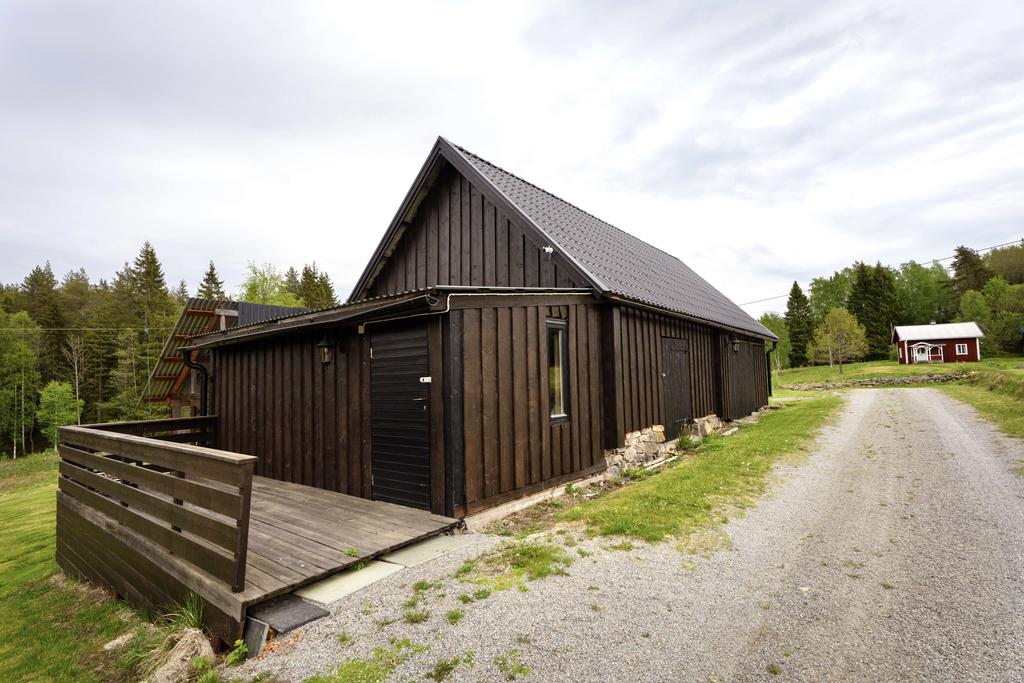 Fristående uthus. Vidbyggt vedförråd på baksidan. 