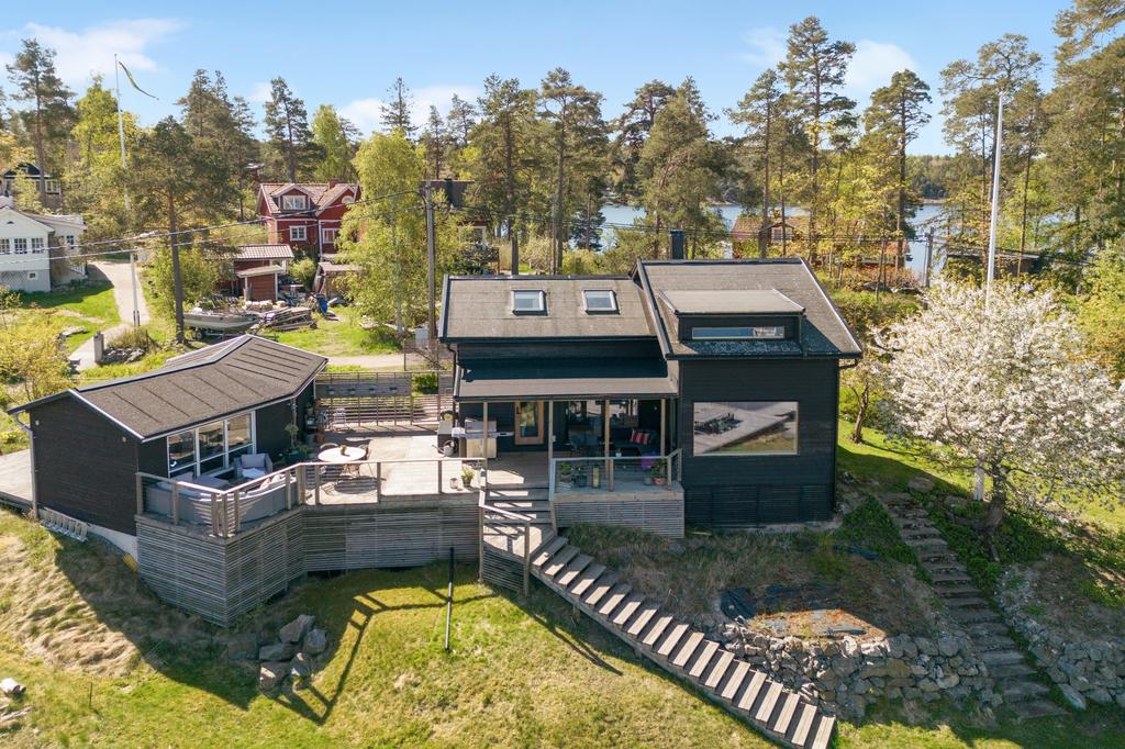 Rymligt trädäck med gott om plats för loungemöbler, grillplats, matplats och frukostbord vilket binder ihop huset på ett socialt och trevligt vis