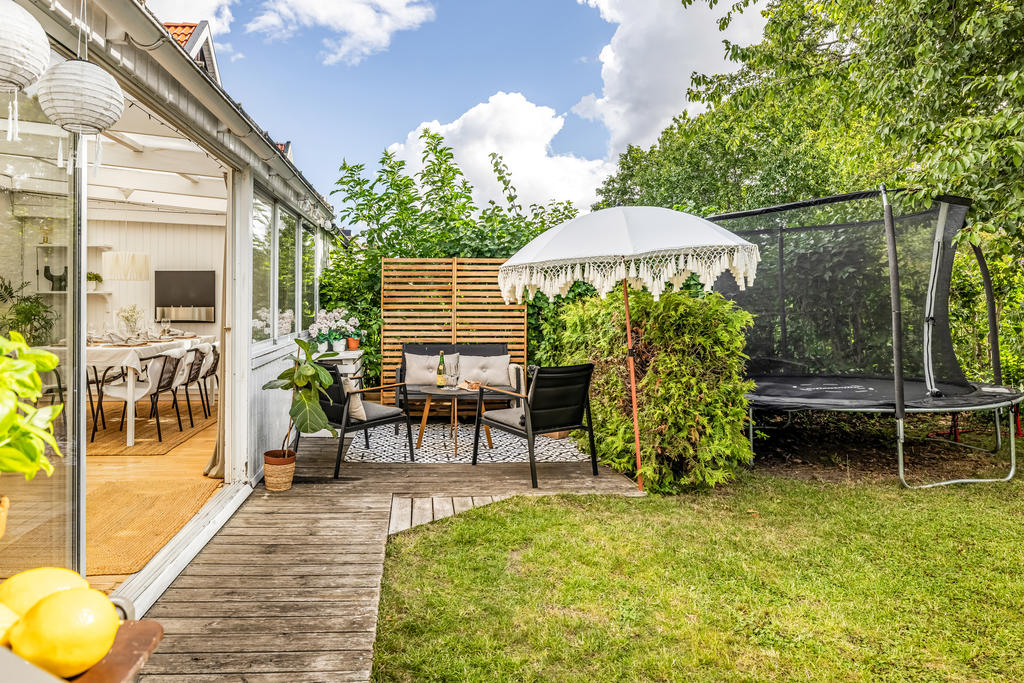 Mysig uteplats inramad av lummig grönska