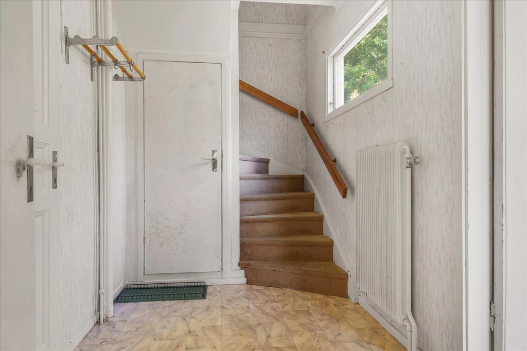 Hall med uppgång till ovanvåning samt nedgång till källarvåning 