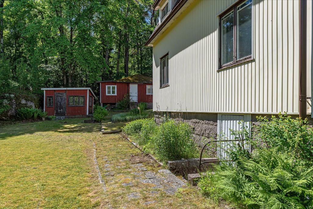 Vy mot gäststuga och förråd samt nedgång till källaren