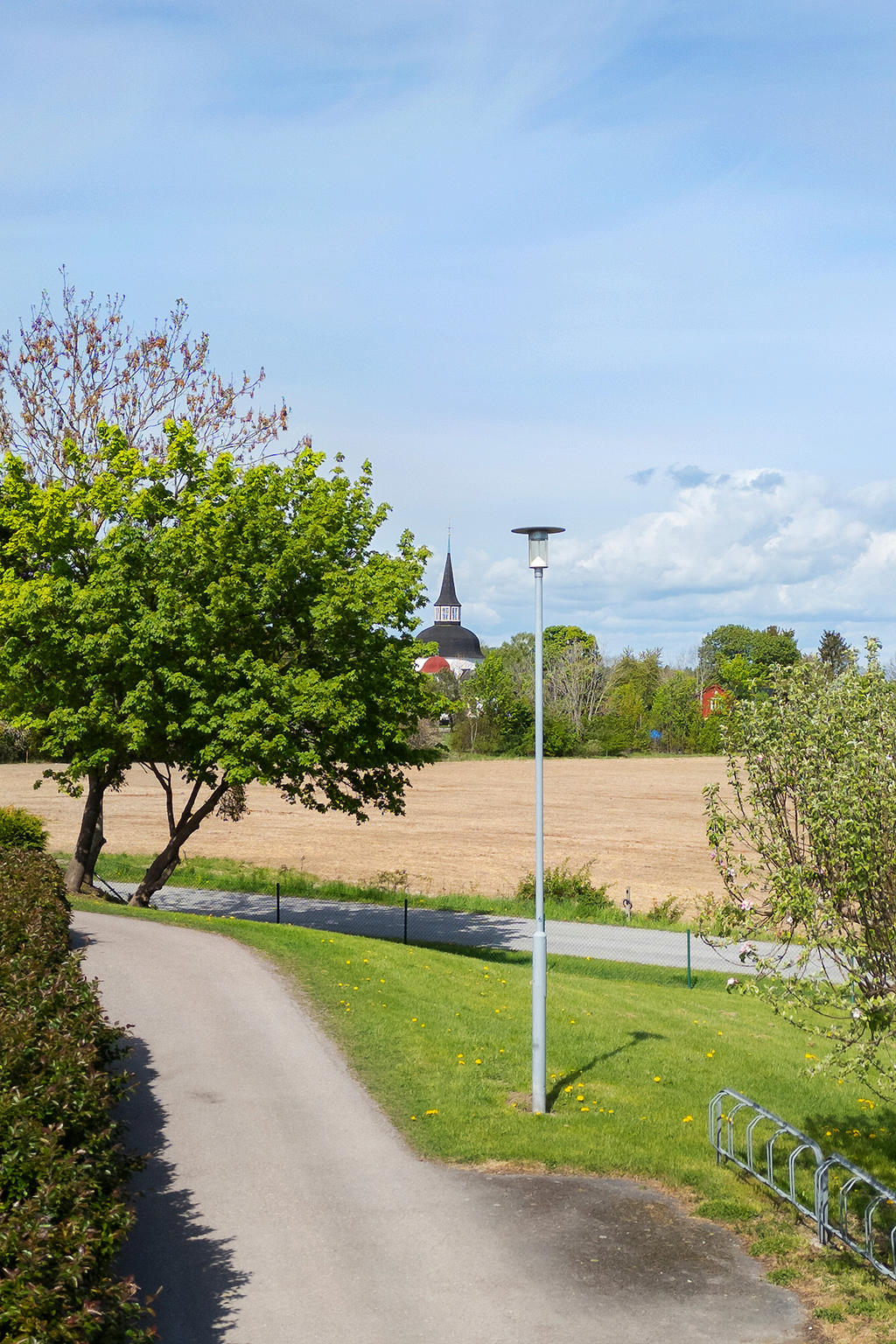 Fantastisk vy över öppet landskap mot Munsö kyrka