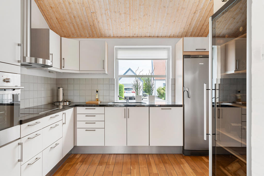 Påkostat HTH-kök med stenbänkskiva och stor vinkyl.