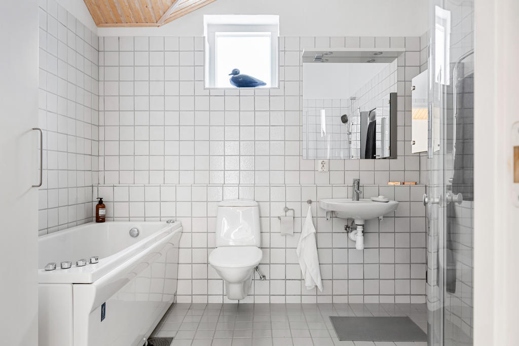 Stort och ljust badrum med både badkar och dusch. 