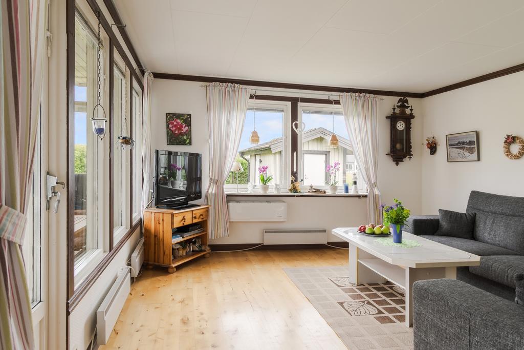 Ljust vardagsrum med stora fönsterpartier som släpper in rikligt med dagsljus. En trivsam samlingsplats för hela familjen.