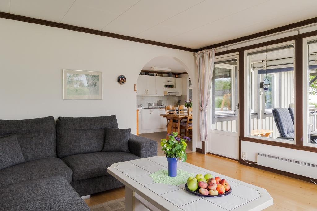 Trivsamt vardagsrum med plats för en större soffgrupp. De stora fönstren ger fin kontakt med trädgården och omgivningarna.