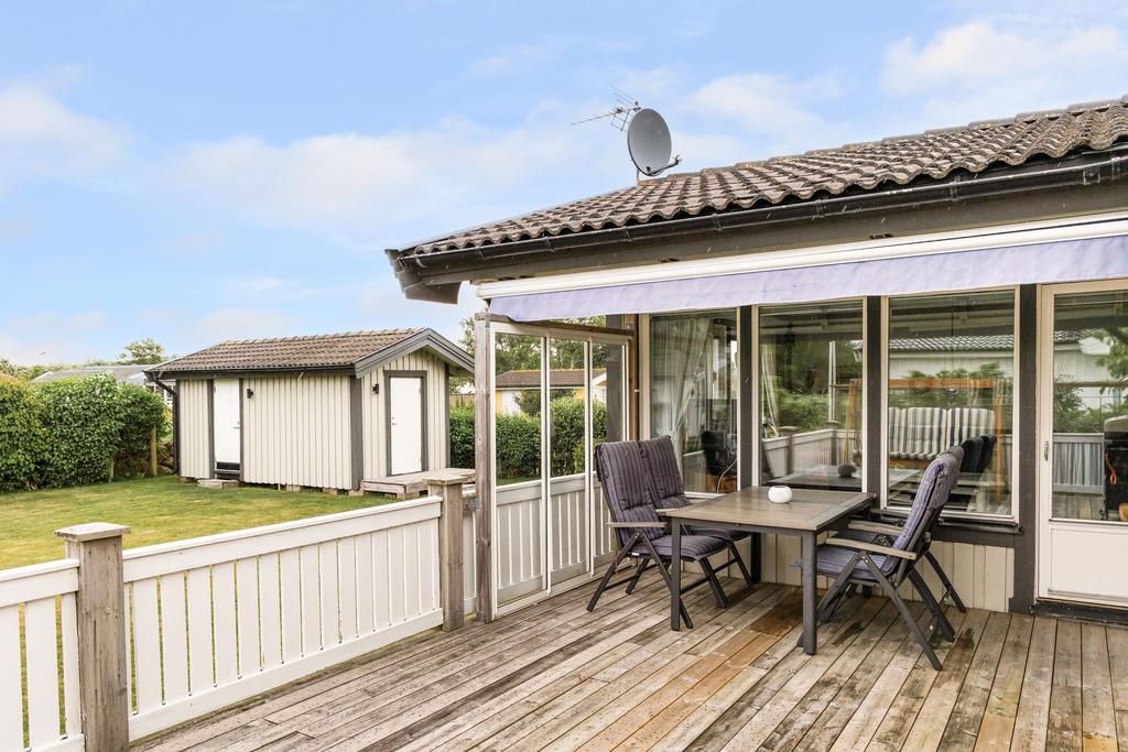 Skyddad uteplats med plats för både måltider och umgänge, utrustad med elektrisk markis som ger behaglig skugga under soliga dagar. Ett härligt komplement till bostadens sociala ytor.