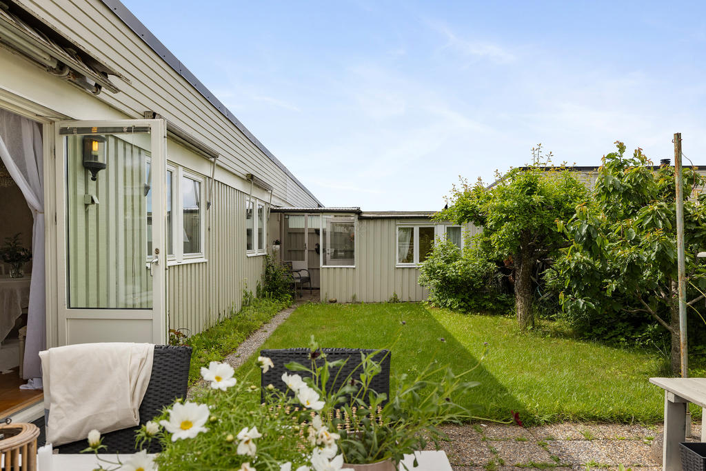 Trädgården är insynsskyddad och  bjuder på såväl altan, stenläggning, gräsmatta och fruktträd och planteringar 