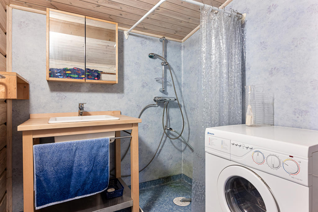 Våtrum i boden invid huset. Duschhörna, tvättställ och tvättmaskin