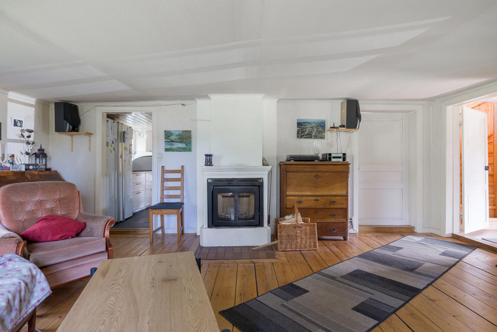 Bostadshuset har bevarat mycket av sin charm och karaktär med breda golvplankor, vedspis och flera tidstypiska detaljer som skapar en varm och genuin atmosfär.