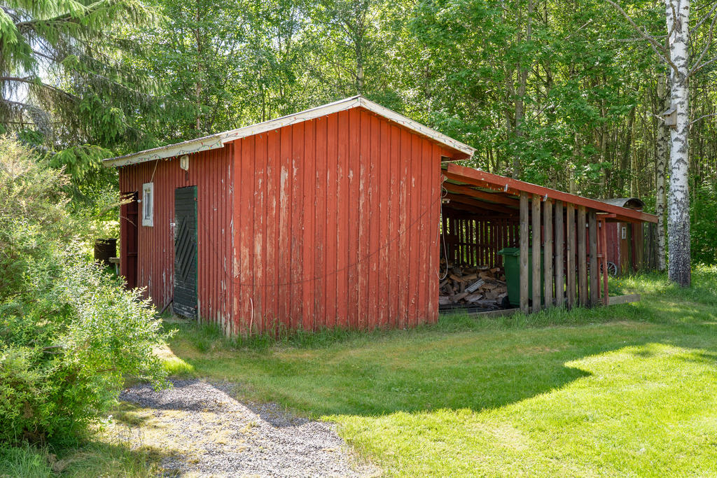Verkstad med vidbyggt vedförråd.