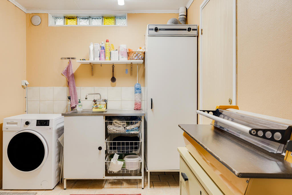 Tvättstuga med dörr till både garage och separat duschutrymme.