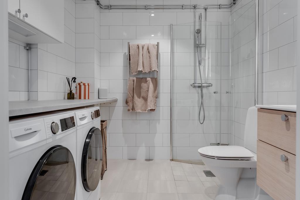 Helkalkat badrum med dusch, tvättmaskin och torktumlare
