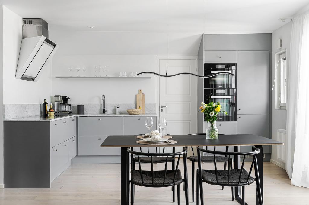 Stilrent kök i grått och plats för stort matbord 