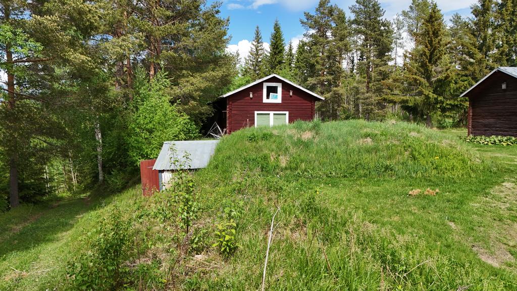 Till höger, väg ner till mark och Ångermalnadsälven. Jordkällare samt timmerstuga.