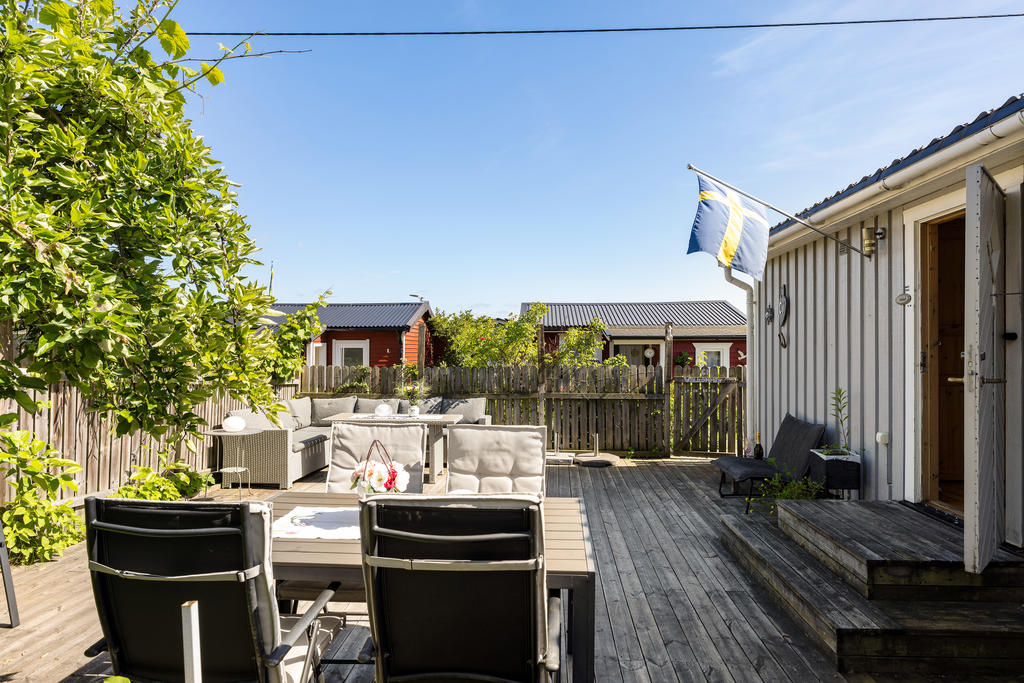 Solig altan med mycket plats för såväl loungegrupp, matbord, planteringar och lek