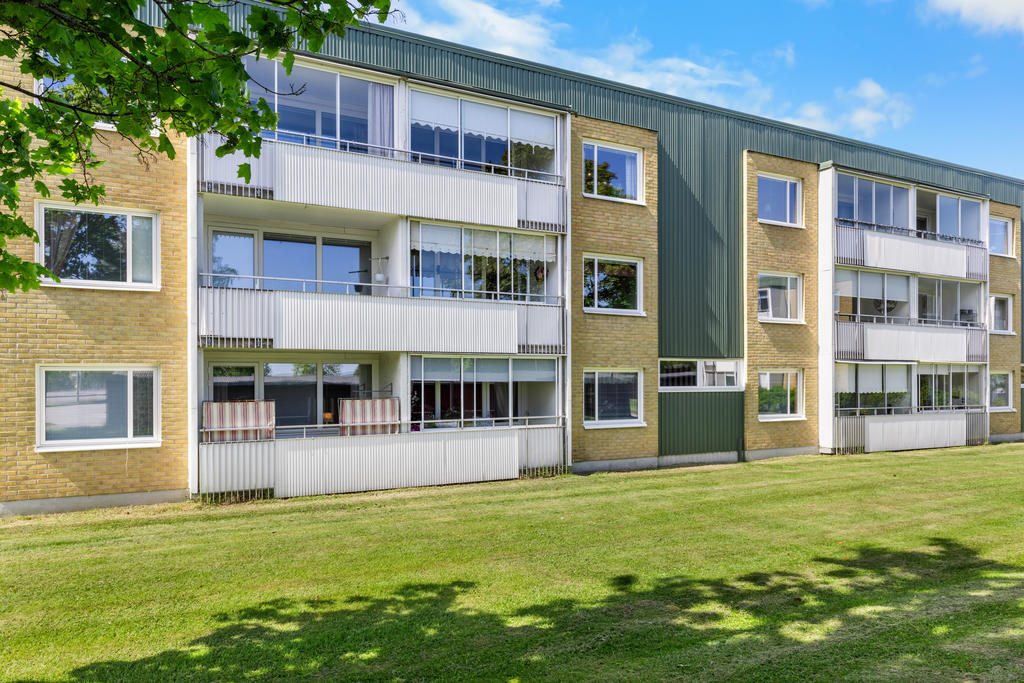Inglasad balkong med förmiddagssol. 