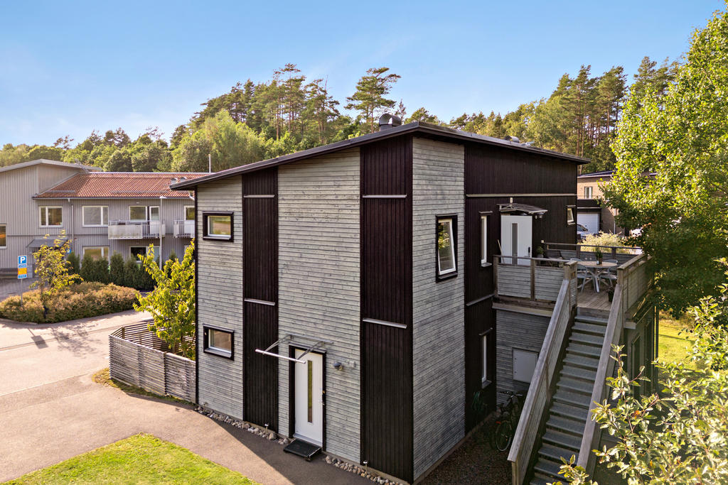 En modern trea med villakänsla, omgiven av grönska