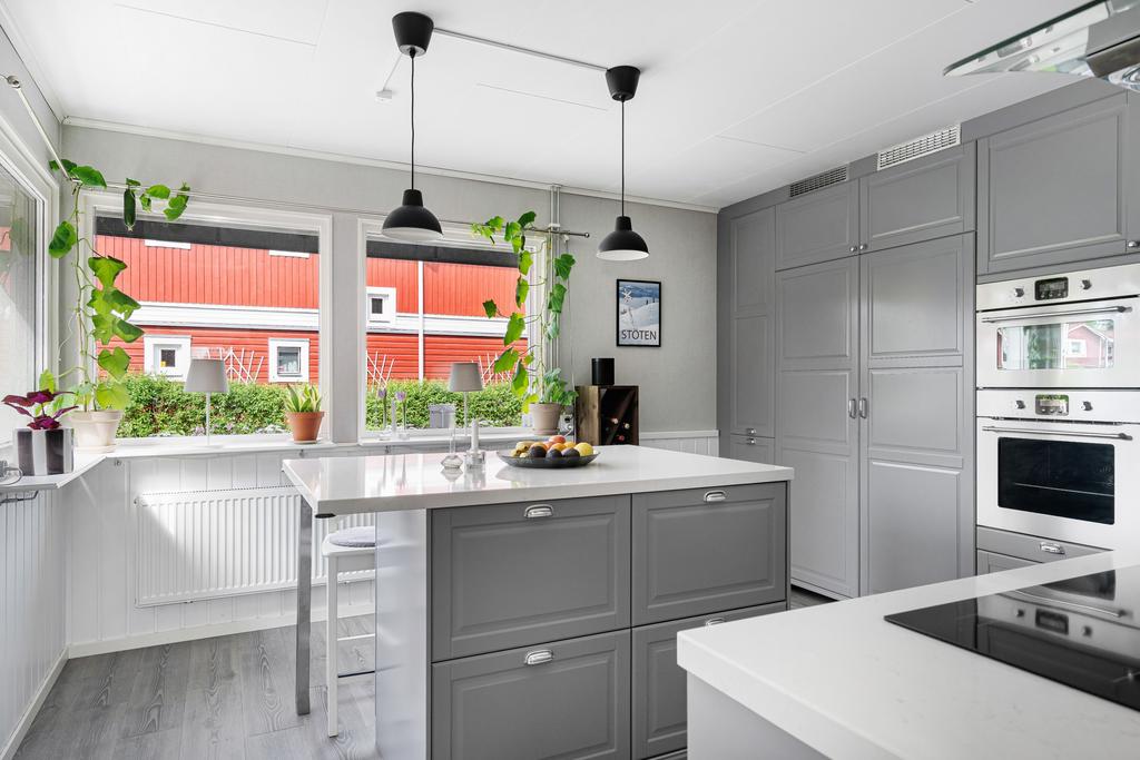 Kök i vinkel med integrerade vitvaror och köksö
