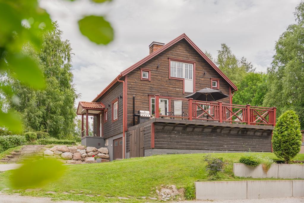 Charmig familjevilla med vacker träfasad, uppvuxen tomt och stor altan för umgänge och avkoppling.