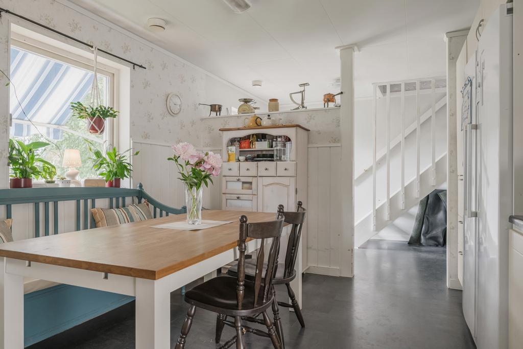 Köket ligger praktiskt placerat i direkt anslutning till entrén och erbjuder en naturlig matplats intill fönstret.