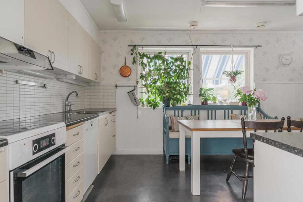 Praktiskt kök med goda förvaringsmöjligheter och en inbjudande matplats.