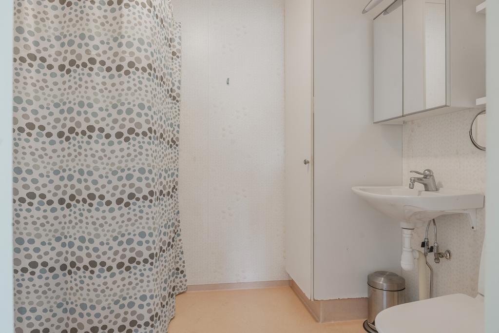 Badrum på entréplanet utrustat med dusch, wc och handfat. Rummet är i behov av renovering, vilket ger nästa ägare möjlighet att skapa ett badrum efter egen smak och stil.